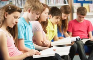 Teenage Students In Library Reading Books