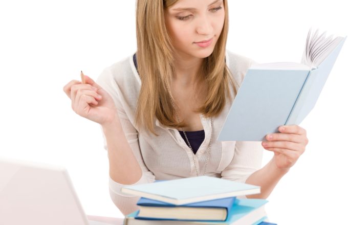 a young woman reads and takes notes