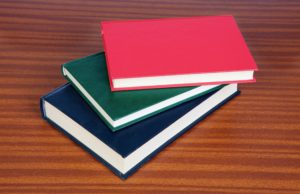 a plie of three books on a table