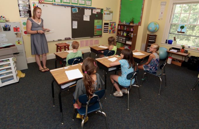 Students and a teacher in a small classroom