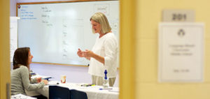woman talking to an adult student in front of a whiteboard