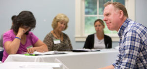 adult male talking to a group of adult students in classroom