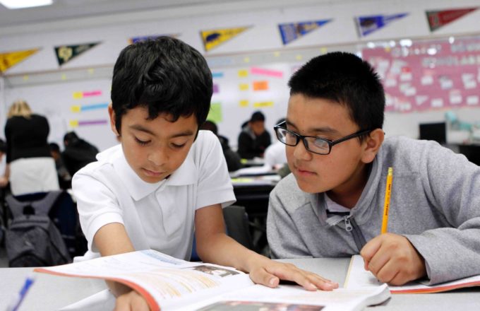 Two young boys working together in a classroom