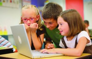Children gathered around a computer