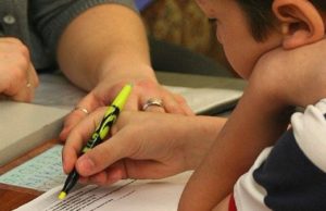 Student works with educator to apply active reading strategy of highlighting to support comprehension.