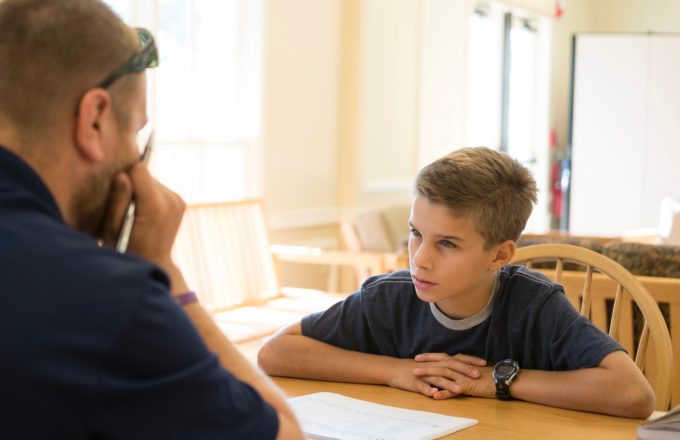 A student and a teacher having a discussion at a table