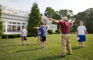 Students and a teacher on the lawn exercising