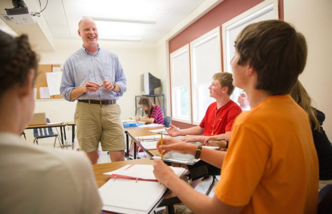 A man speaks to a classroom of boys