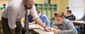 teacher helping a student at his desk