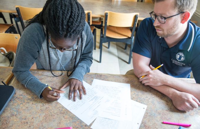 A student and a teacher work on writing together