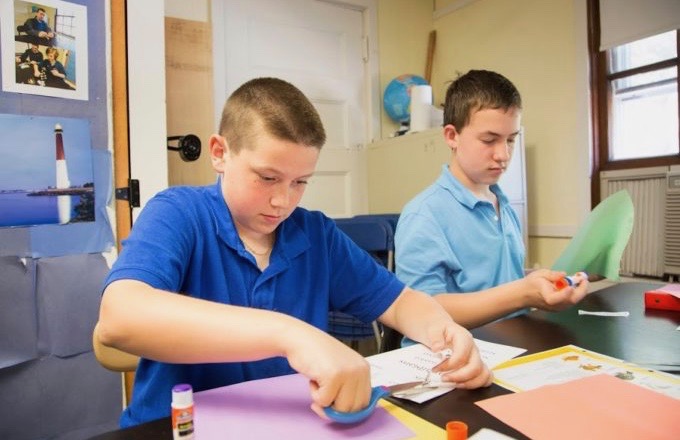 Two young boys working together in a classroom