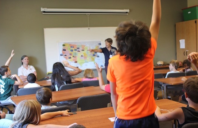 Students eagerly participate in a classroom lesson