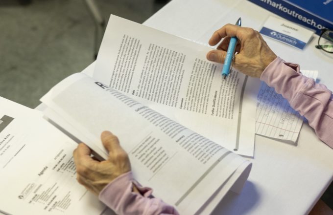 Person holding papers and a pen