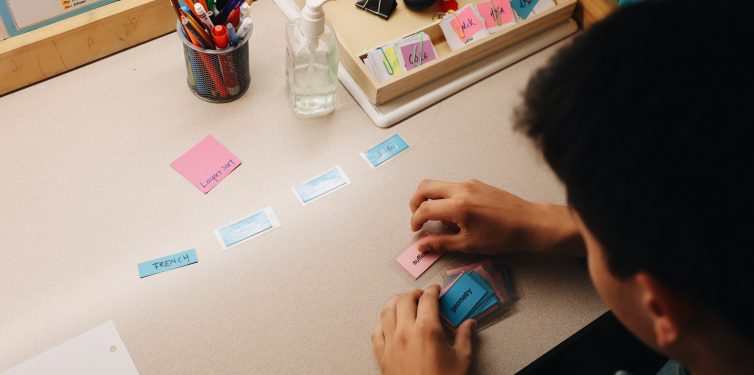 Birds-eye view of student conducting sort with colored cards.
