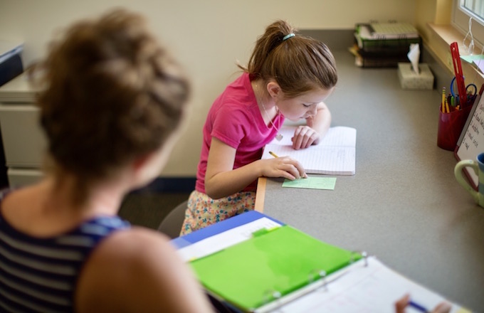 Student practices vocabulary words in structured exercises with support from teacher