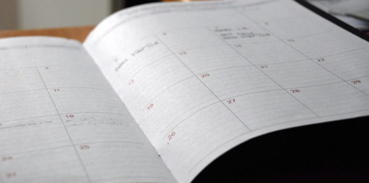 Paper calendar open on a desk.