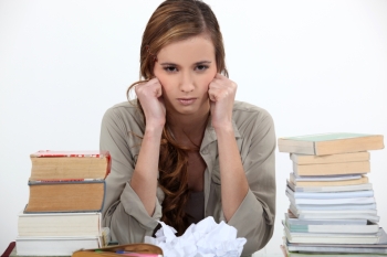 A unhappy students sitting among books