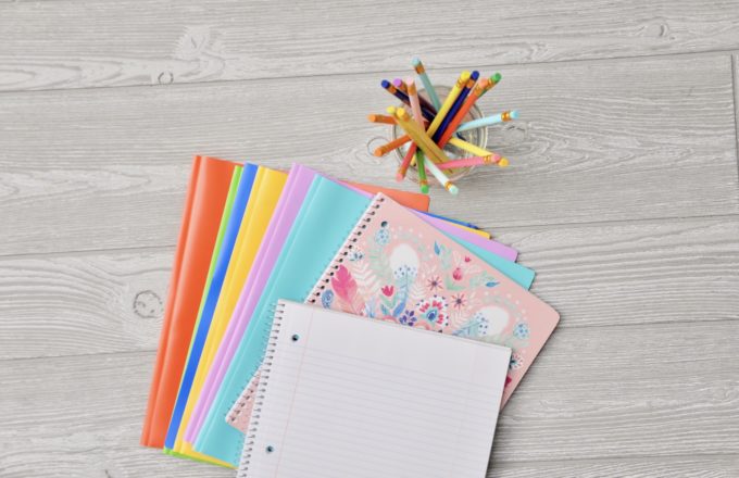 A stack of colorful notebooks and folders.