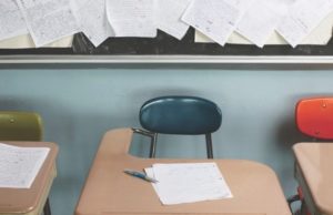 A desk with a paper on it and papers pinned behind it