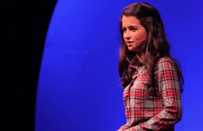 An image of Piper Otterbein giving her talk on a stage at a TED talk