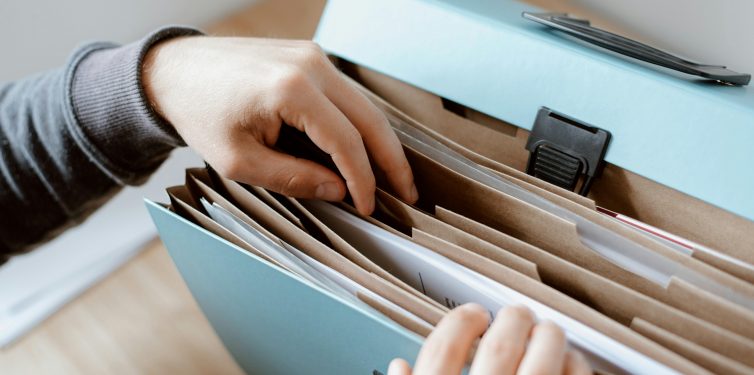 Student rifling through an organized accordion folder.